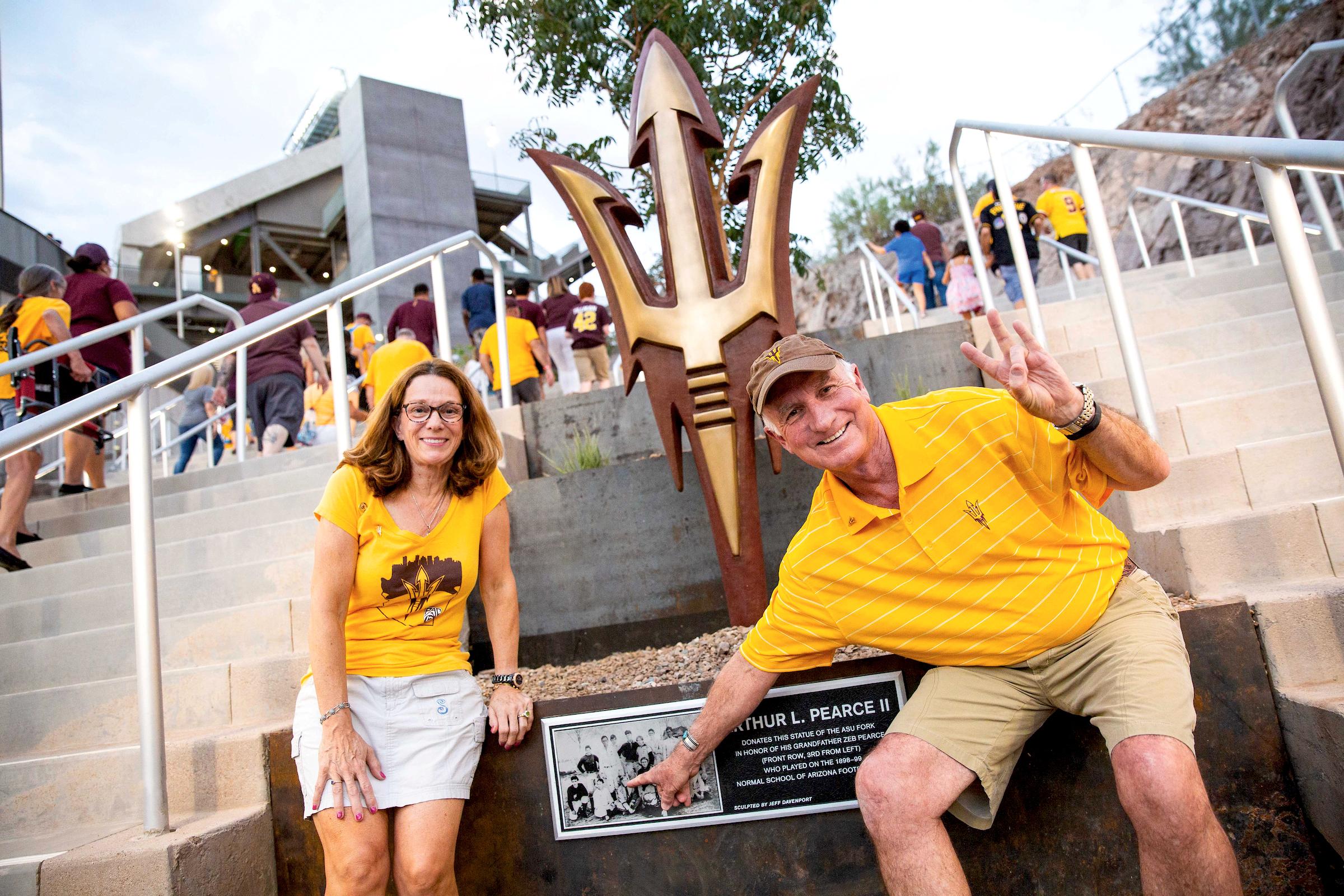 ASU Now - ASU vs. UTSA football game. A couple attending the game is standing in front of a sign reading Arthur L. Pearce II.