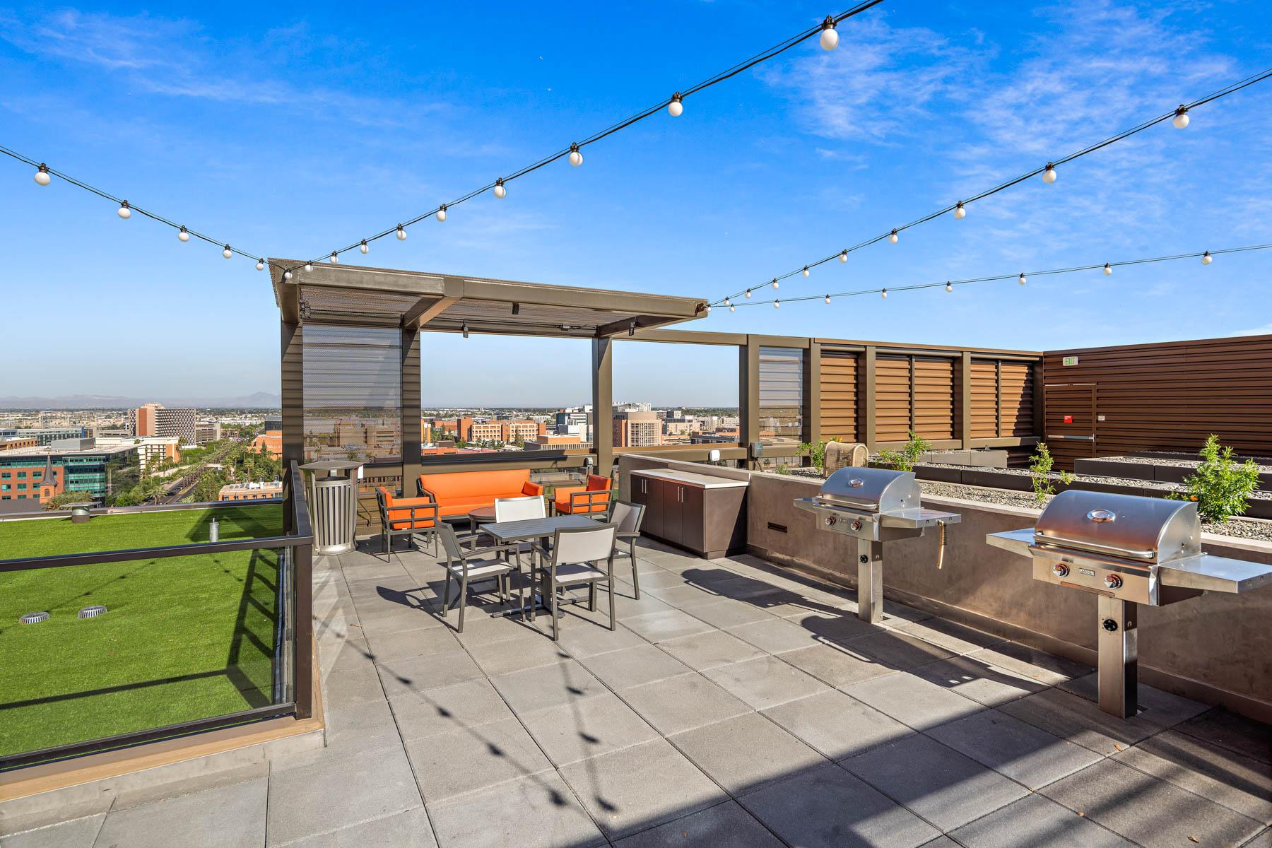 A rooftop patio at Mirabella at ASU. There are grills, tables and chairs and comfortable couches.